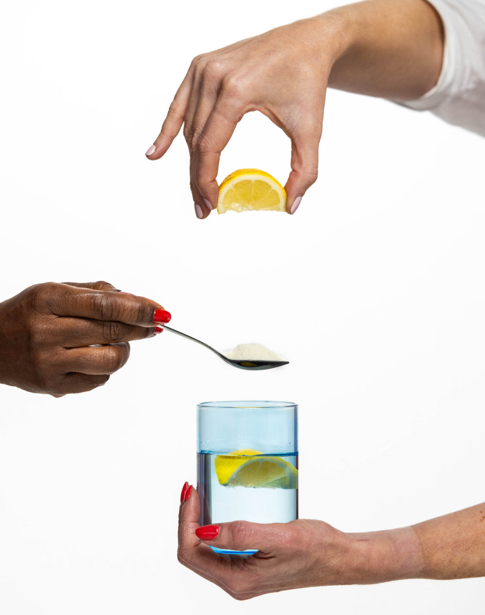 Collagen powder on a spoon with a glass of water and vitamin C rich lemons